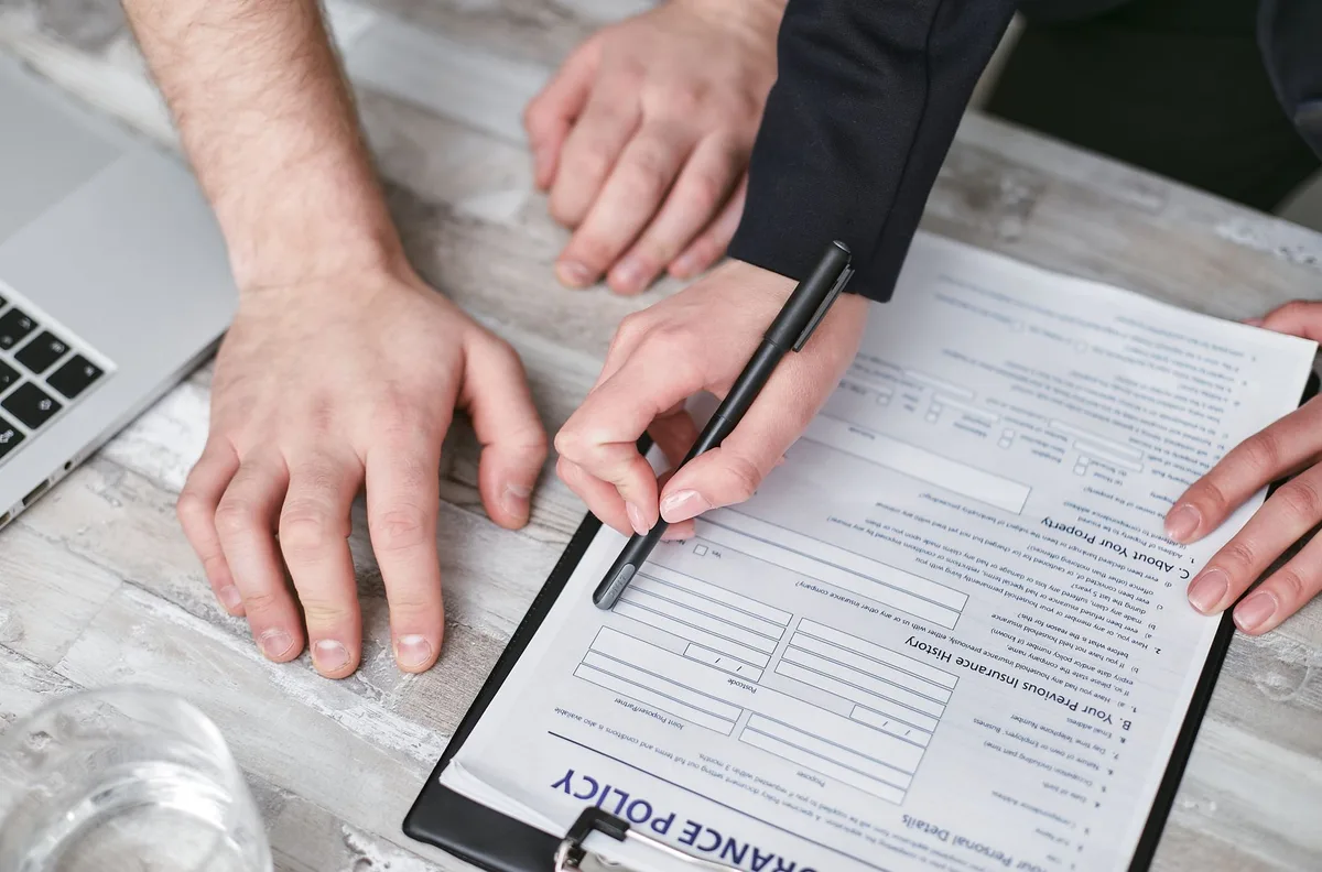 Insurance policy documents with a pen on a wooden desk, ready for review
