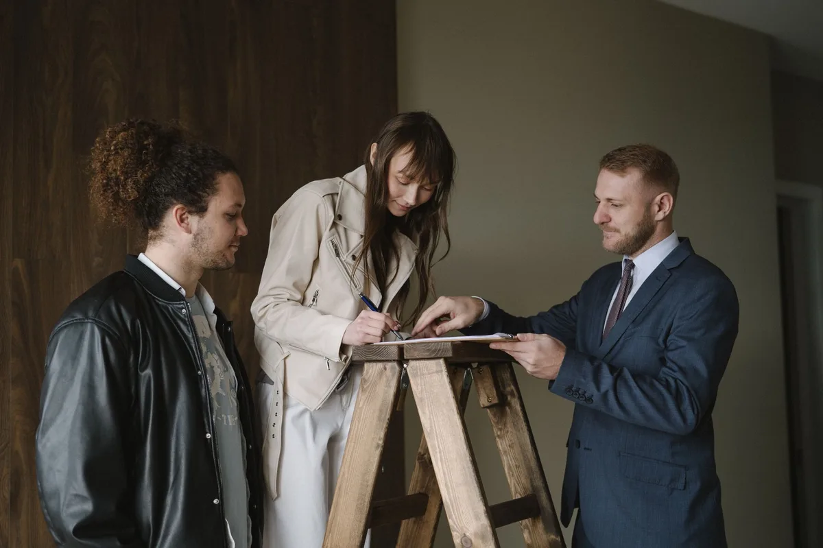 Person signing property investment contract on wooden desk