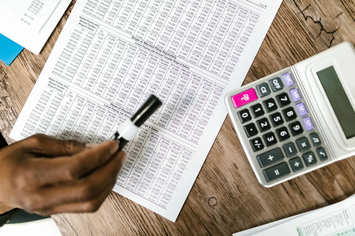 Calculator resting on tax documents and financial spreadsheets