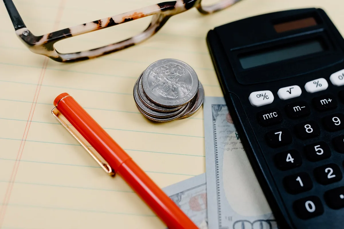 Planning desk with notebook, pen and financial documents representing systematic budgeting