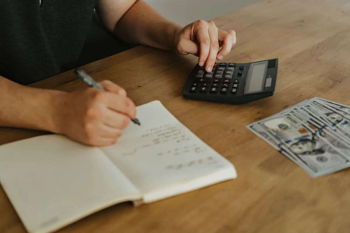 Planning desk with notebook, pen, and financial documents representing a young investor starting their financial journey