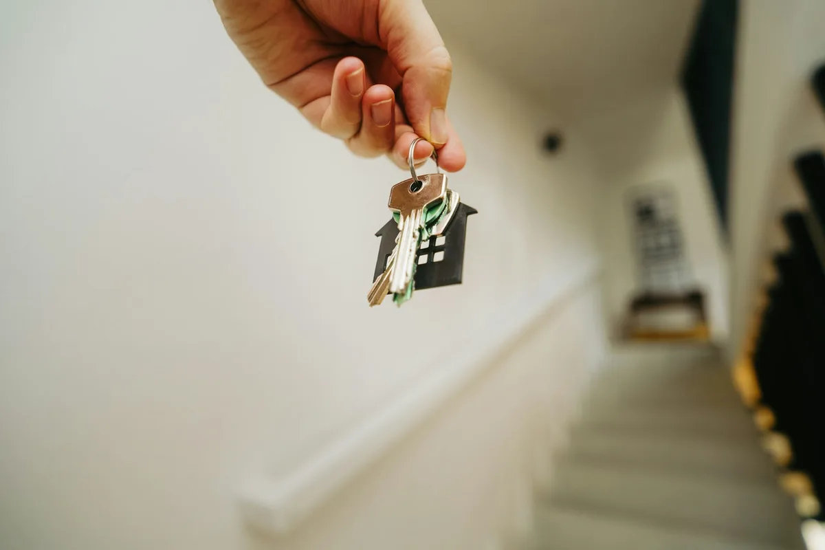 House keys and signed contract on desk representing first home purchase in Canada
