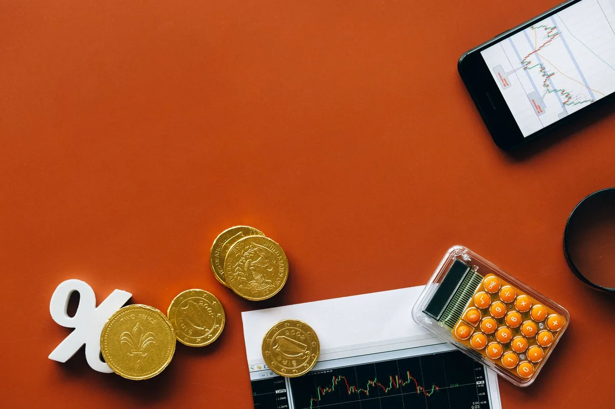 Calculator and coins on financial documents representing savings planning