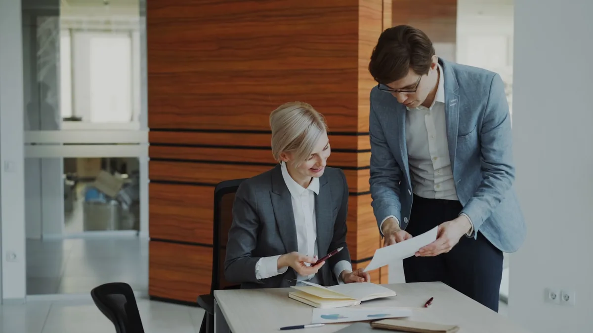 Professional colleagues discussing workplace pension planning in an office setting