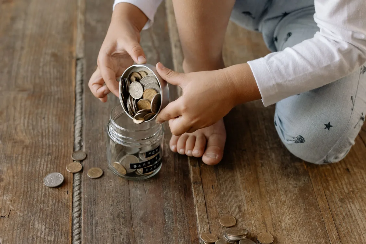 Glass jar containing British pound coins representing emergency fund savings
