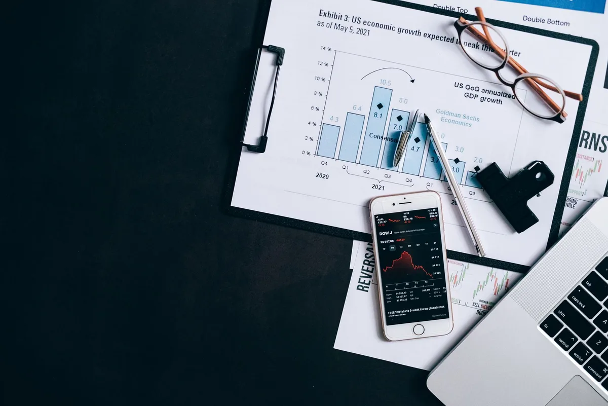 Financial charts and laptop showing investment analysis on a desk
