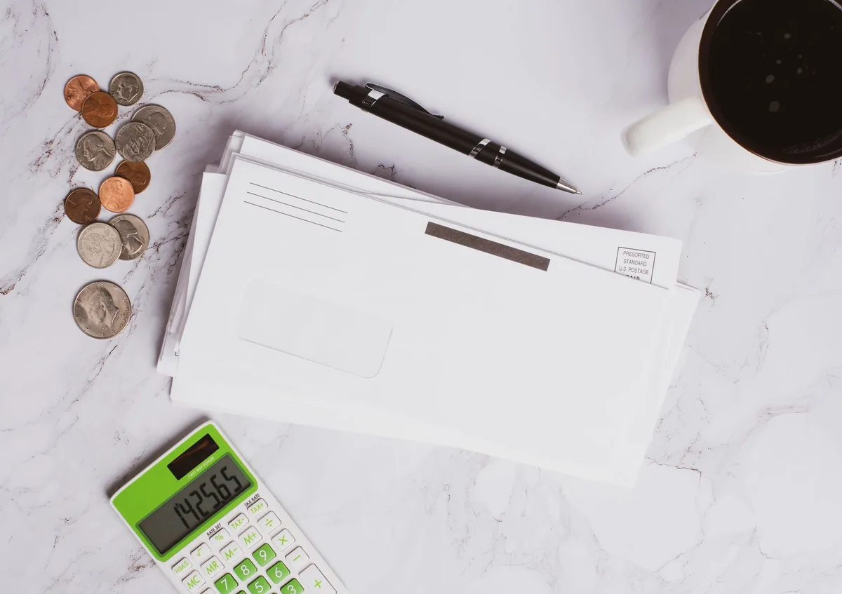 Calculator and coins on a desk representing ISA savings calculations