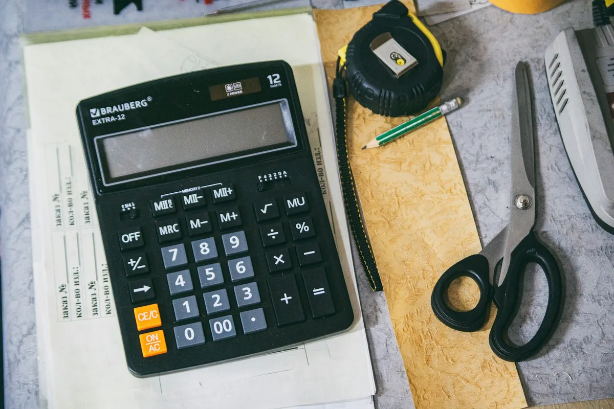 Planning desk with documents, calculator and pen arranged for pension review