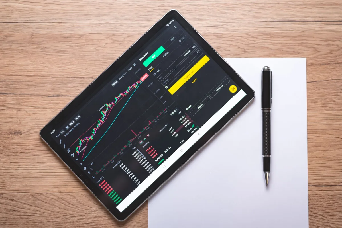 Investment charts and financial data on screens showing portfolio performance