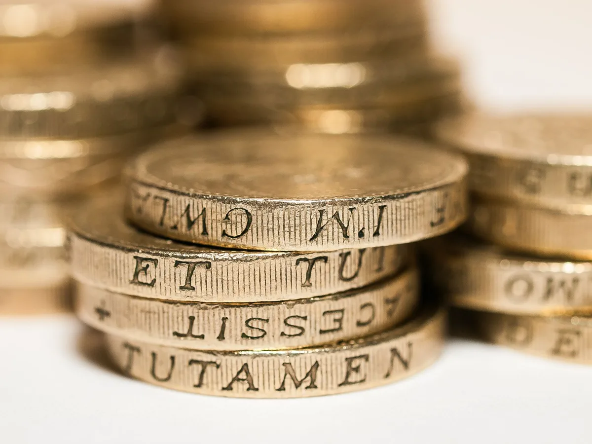 Coins and banknotes arranged on a table representing savings and cash ISA investments