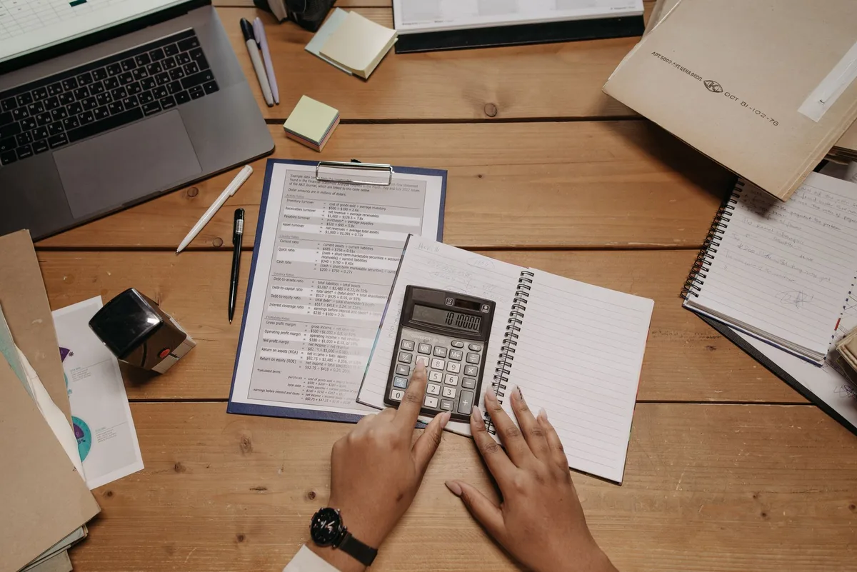 Planning desk with calculator, notebook and financial documents arranged from above