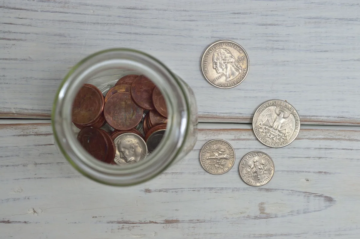Glass jar filled with coins representing personal savings and financial planning