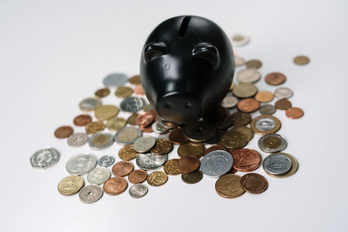 Pink piggy bank beside stacked coins representing education savings planning