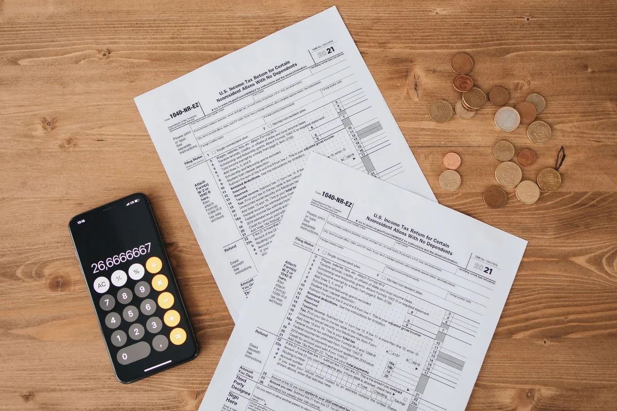 Calculator with coins and financial planning materials on a desk