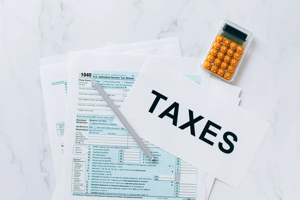 Calculator resting on tax documents with pen