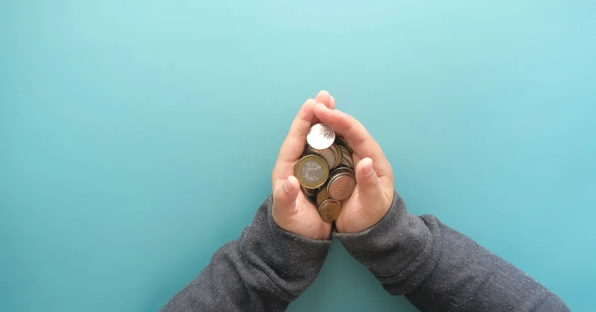 A piggy bank and coins on a table representing personal savings.