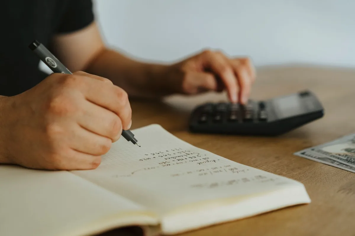 Organized financial planning workspace with notebook, calculator, and documents