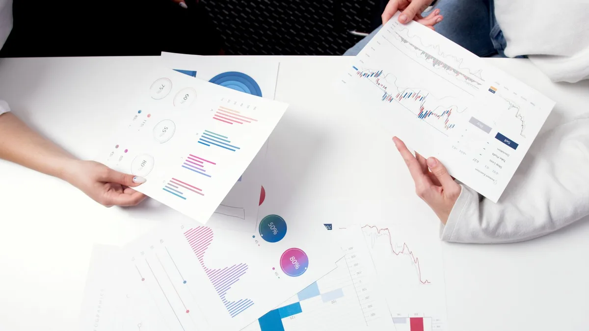 Financial analysis charts and investment portfolio graphs on a desk