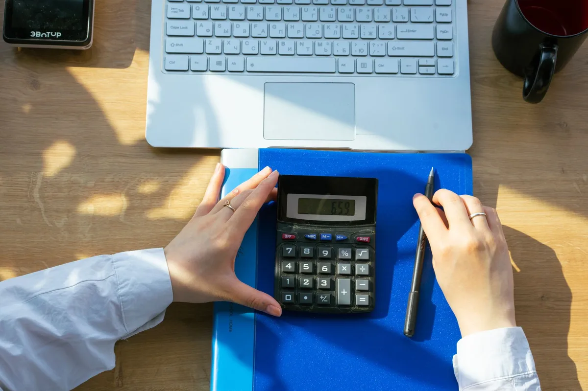 Budget planning desk with calculator, notebook, and pen for fitness expense tracking