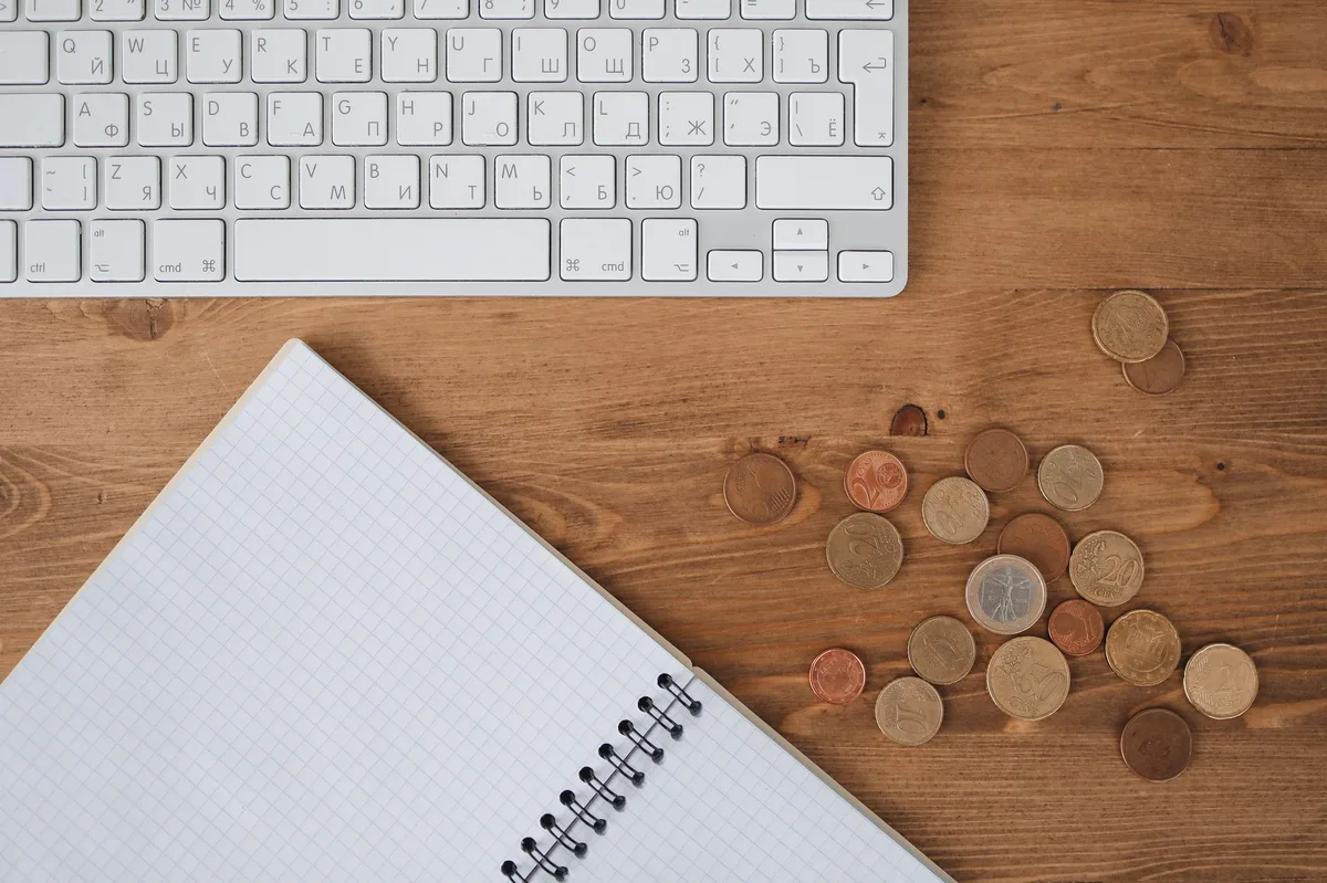 Notebook with financial planning notes and pen on a wooden desk