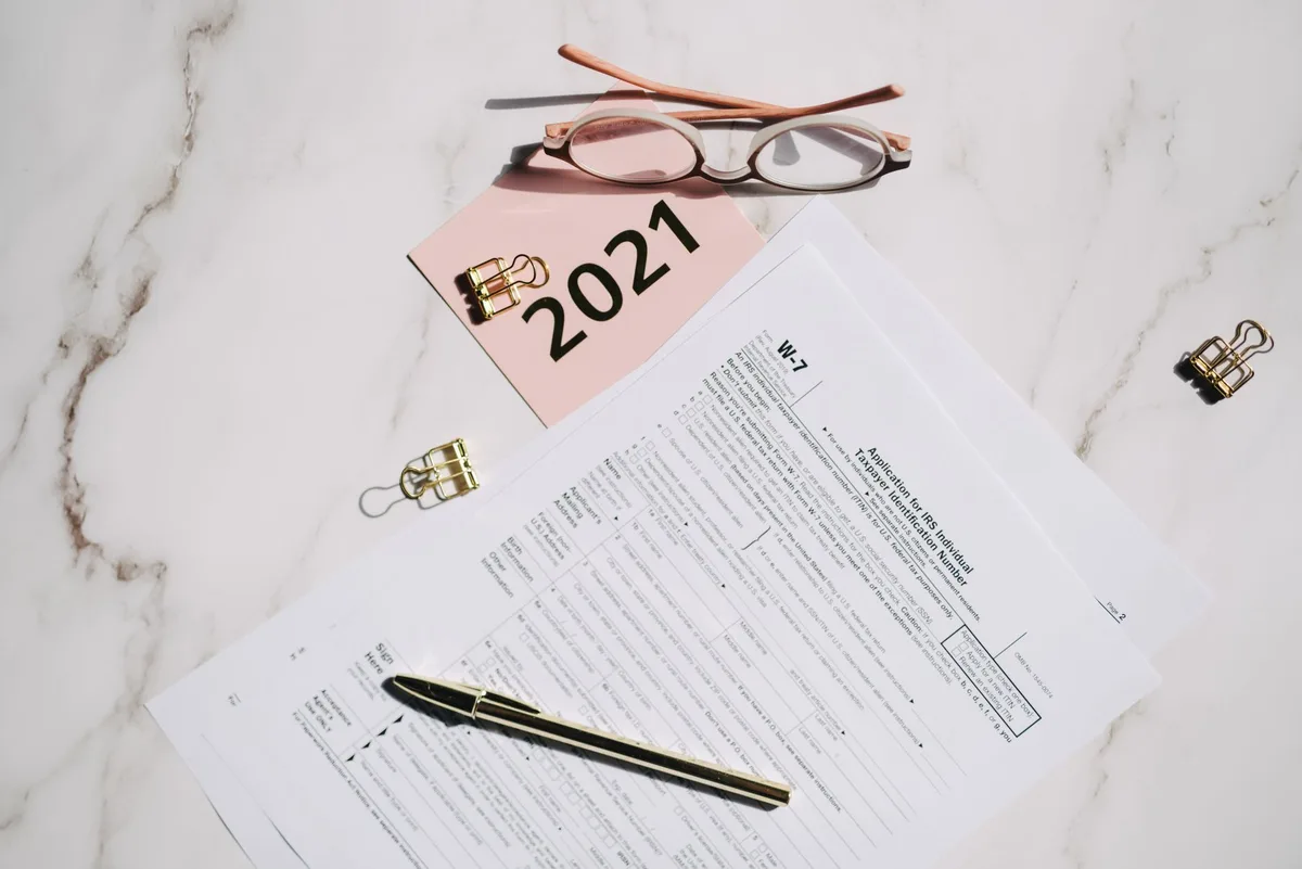 Tax documents and pen on a desk representing retirement account planning
