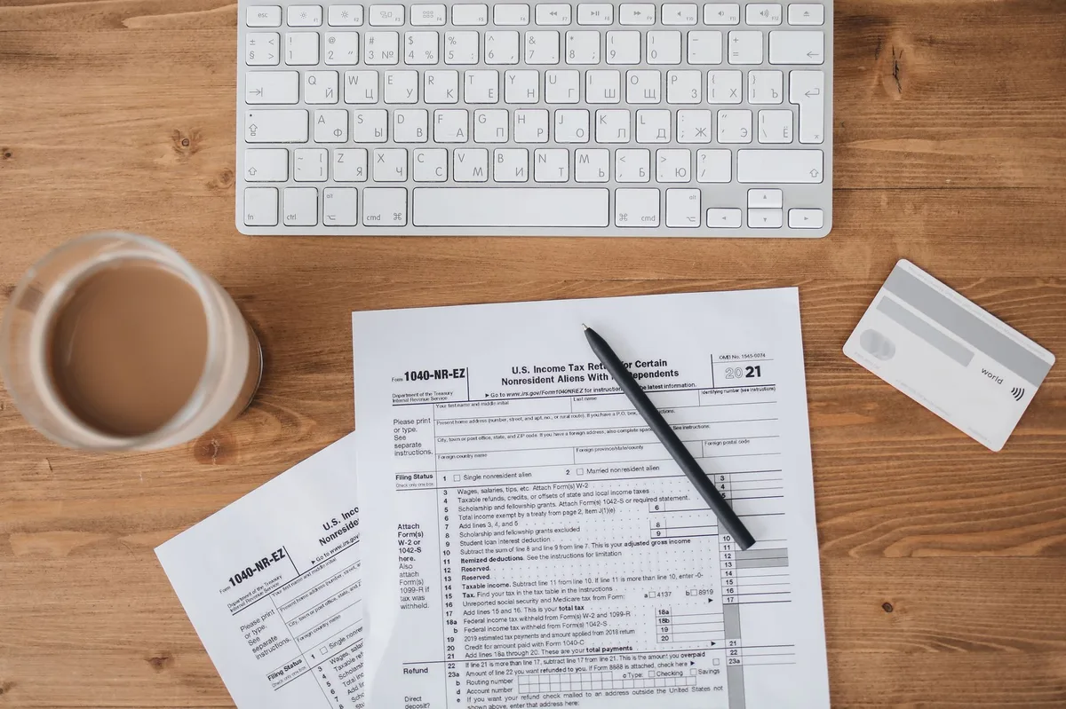 Documents and pen on a desk representing tax forms and retirement planning paperwork