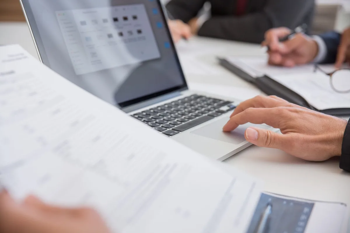 Professional office workspace with laptop and documents on desk