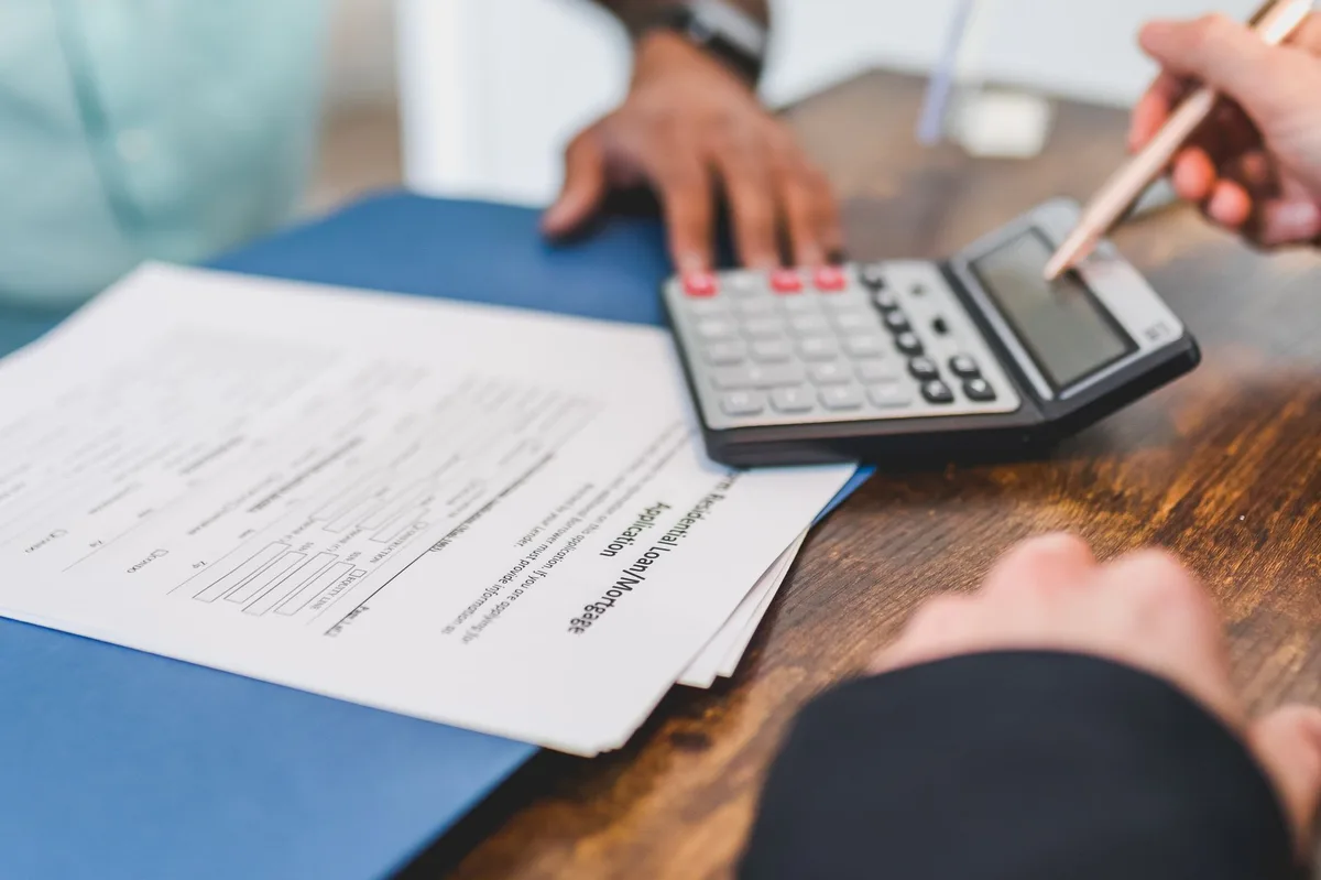 Organized desk with financial documents, calculator and planning materials for student loan repayment