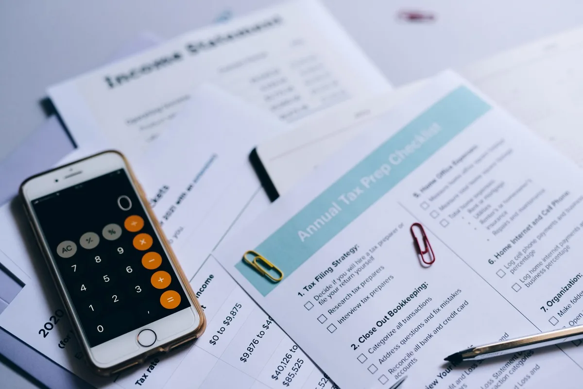 Calculator resting on tax documents with pen for tax planning