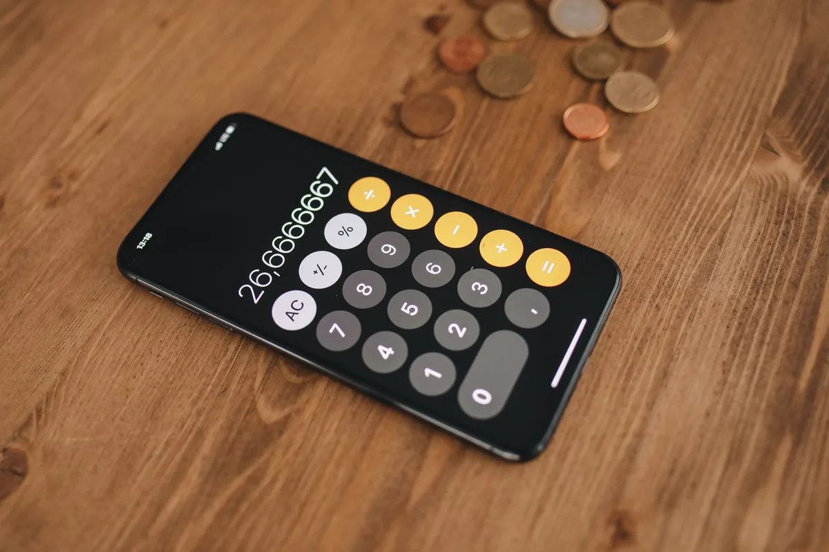 Calculadora com moedas sobre mesa representando planejamento de orçamento