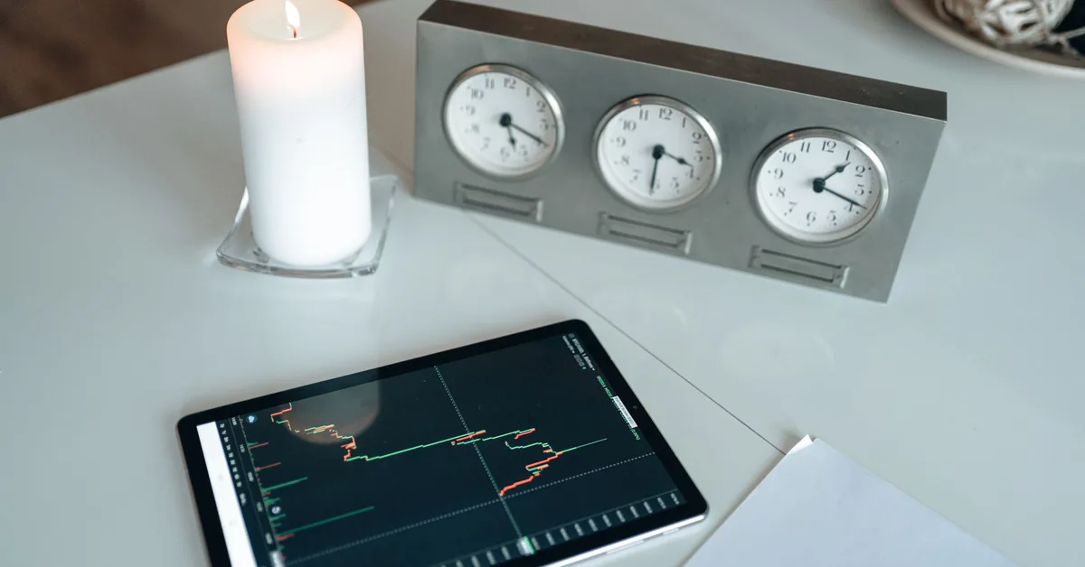 Pessoa analisando gráficos financeiros em uma mesa de trabalho