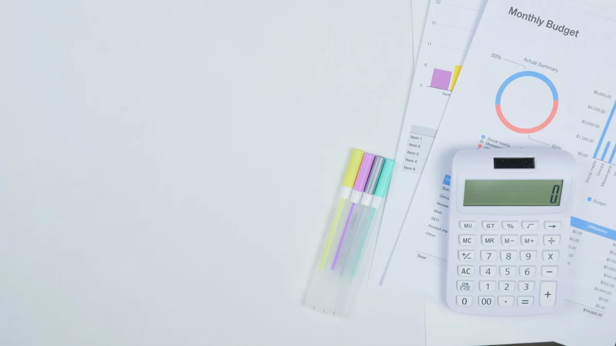 Mesa de trabalho organizada com documentos, calculadora e caneta para planejamento financeiro