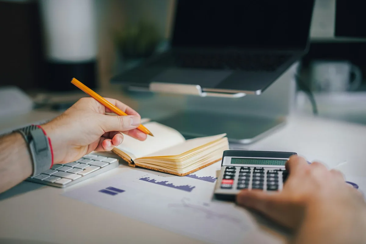 Mesa de planejamento com caderno, caneta e documentos financeiros organizados