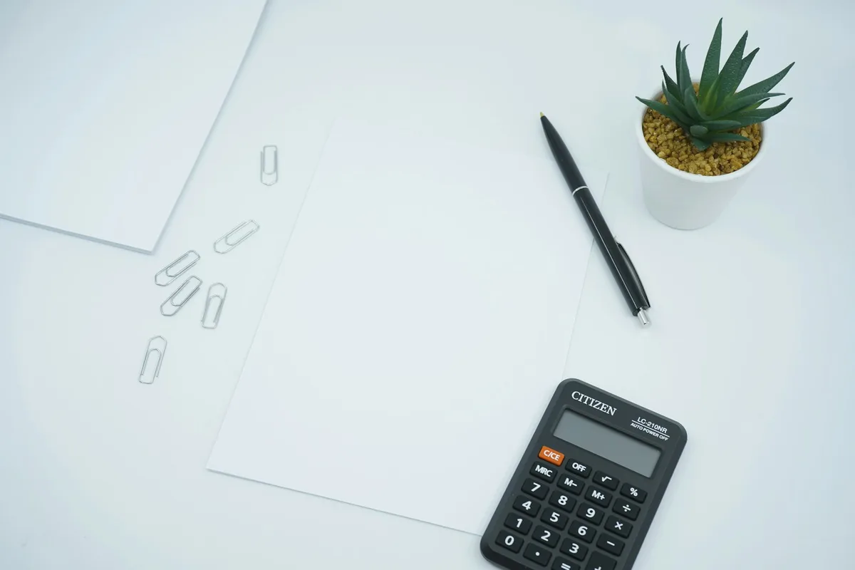 Documentos fiscais e caneta sobre uma mesa de madeira, representando a organização para a declaração de impostos.