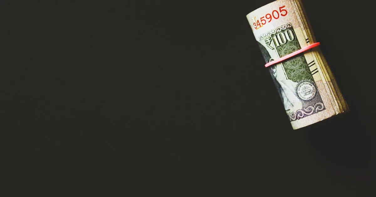 Calculadora e moedas sobre mesa representando controle financeiro e cálculo de despesas
