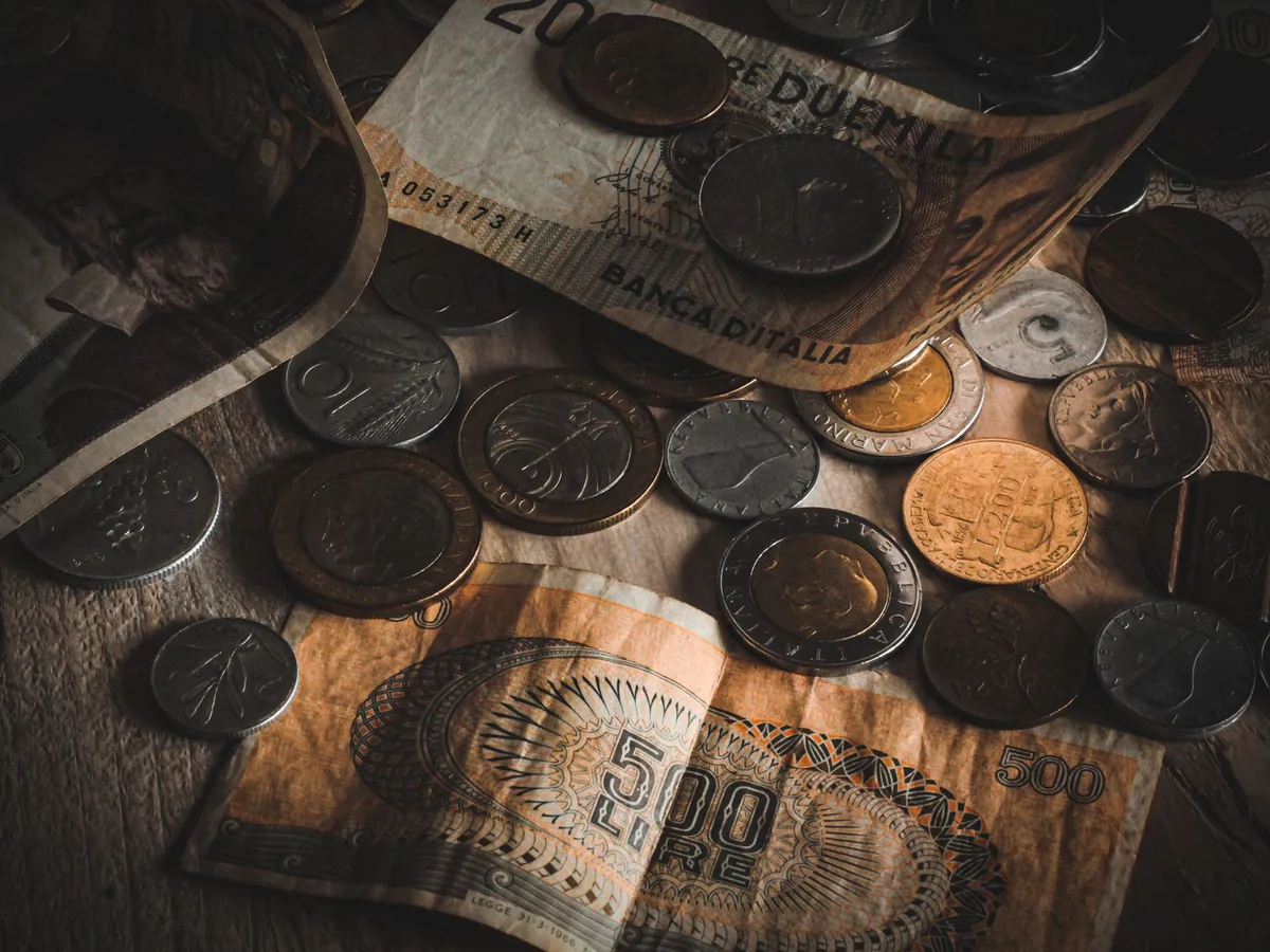 Pote de vidro com moedas e notas representando economia doméstica