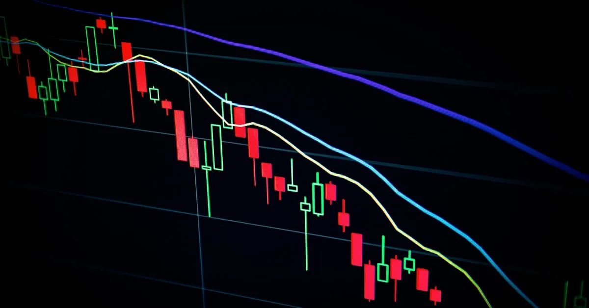 Gráficos financeiros em tela de laptop representando análise de investimentos