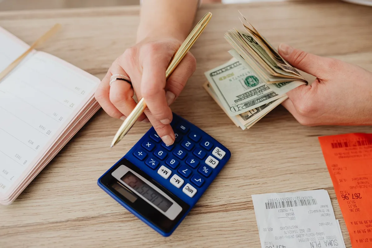 Mesa de planejamento com caderno, caneta e calculadora para organizar orçamento de fim de ano