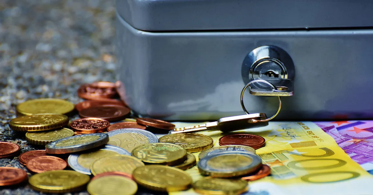 Pessoa analisando gráficos financeiros em uma mesa de trabalho