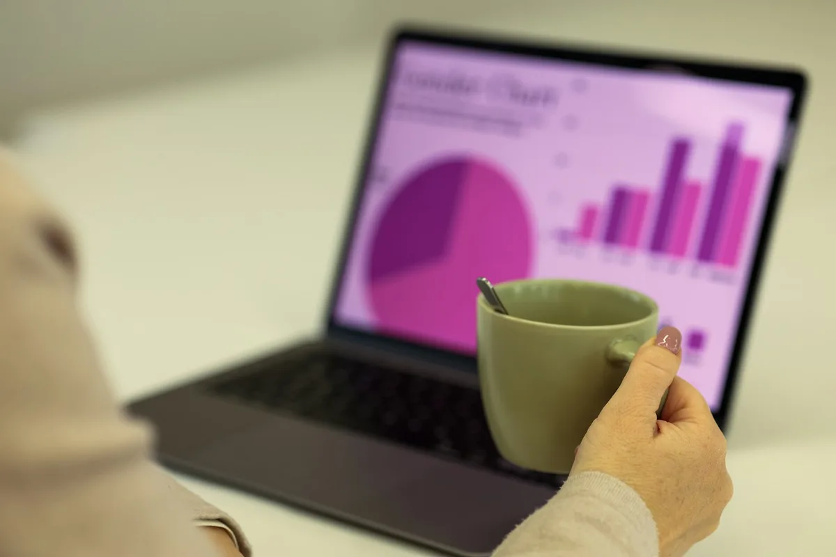 Gráficos financeiros e análise de dados em laptop, representando análise de política monetária