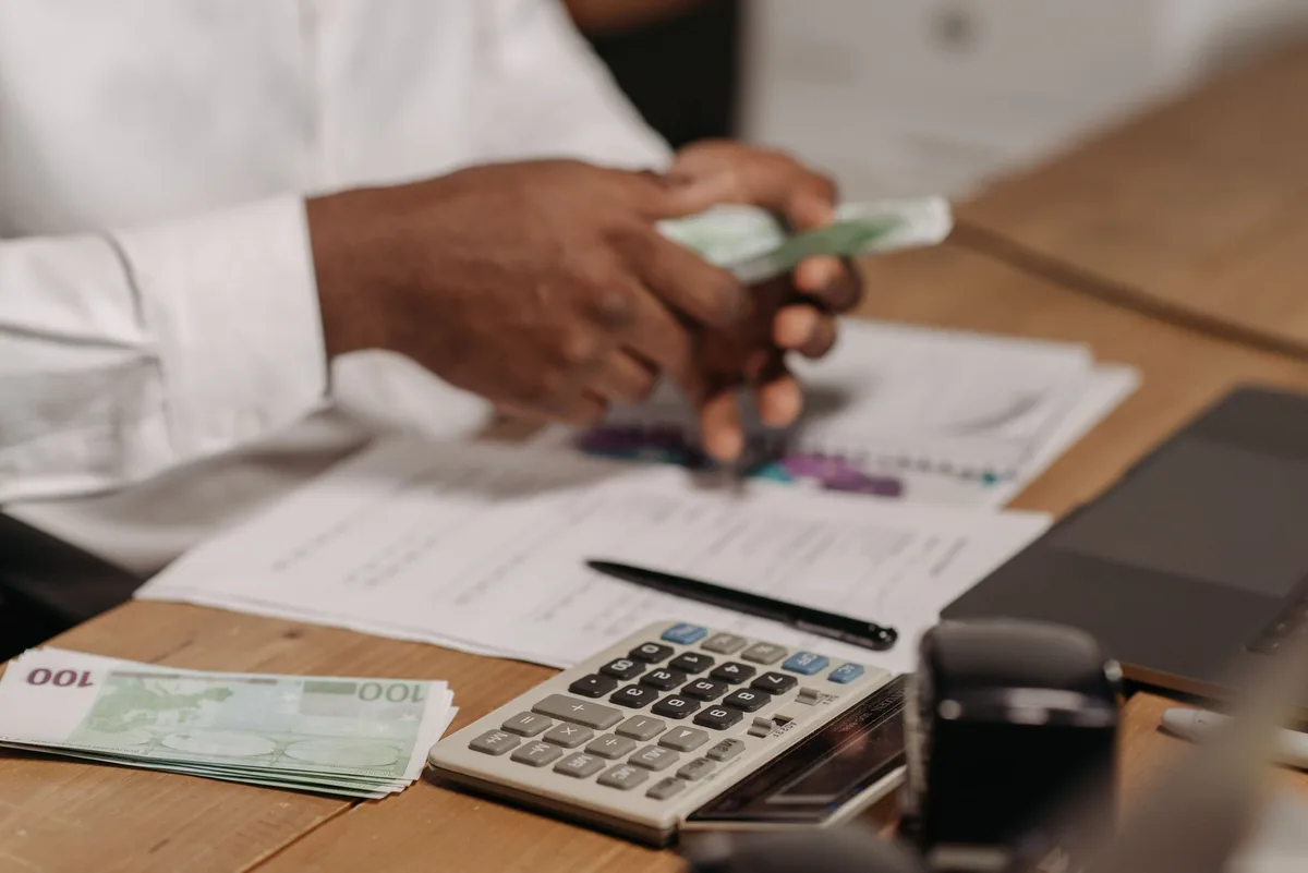 Documentos financeiros e papéis organizados sobre uma mesa, representando planejamento para quitar dívidas