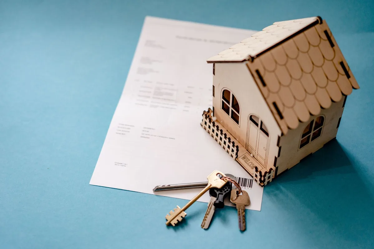 Chaves de casa sobre contrato de financiamento imobiliário com caneta