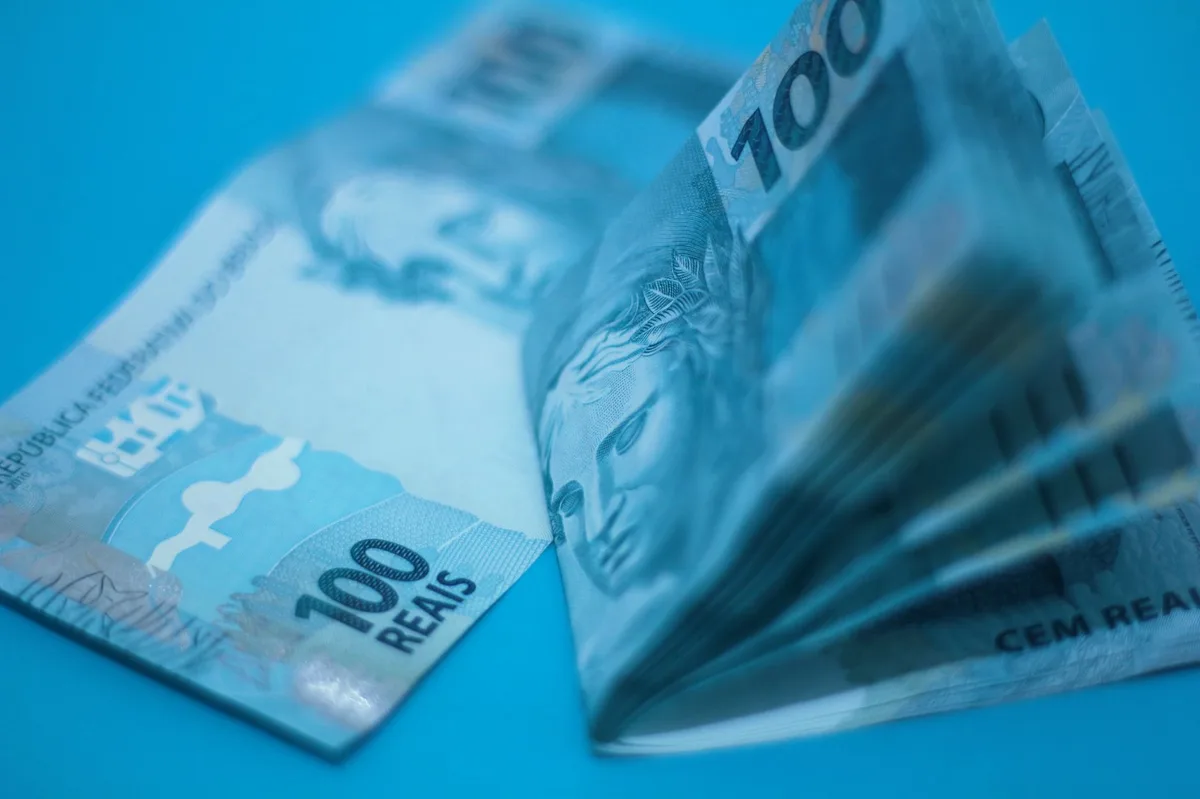 Notas de dinheiro empilhadas representando investimentos em renda fixa