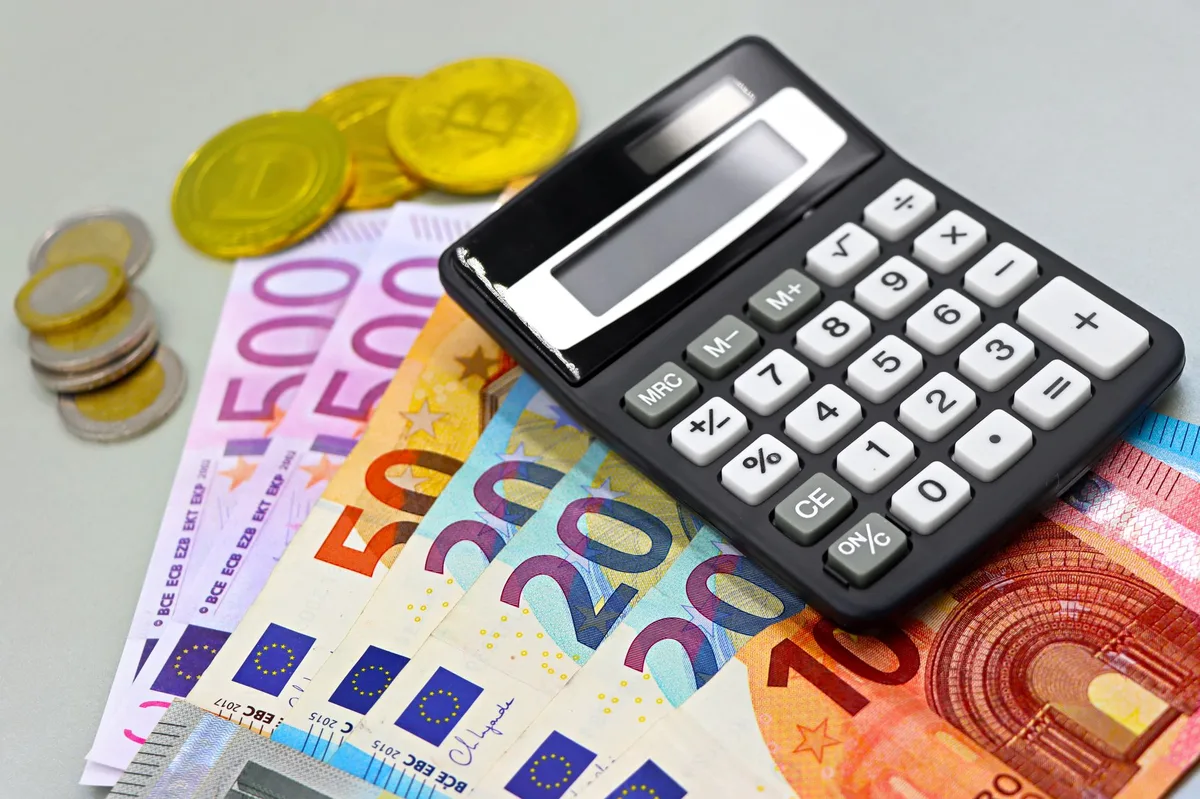 Calculadora e moedas sobre mesa representando planejamento de investimentos em renda fixa