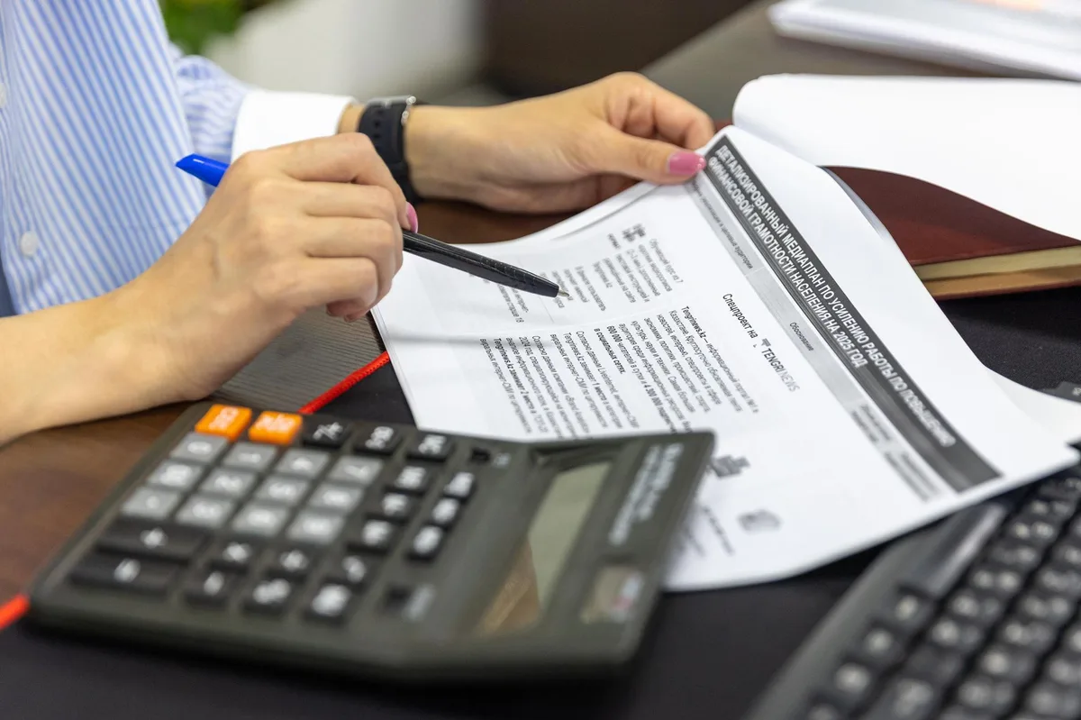 Mesa de planejamento financeiro com documentos, caneta e calculadora