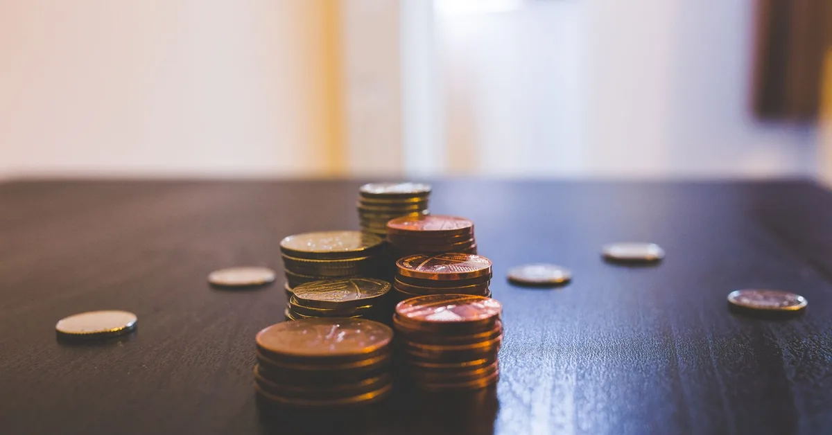 Mesa com calculadora, gráficos financeiros e cédulas para análise de investimentos